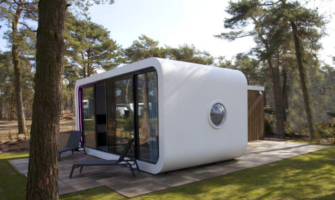 Moderna cabaña Modus L en De Zanding, Países Bajos, rodeada de bosque y grandes ventanales.