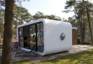 Moderna cabaña Modus L en De Zanding, Países Bajos, rodeada de bosque y grandes ventanales.