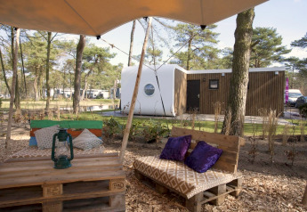 Gemütlicher Sitzbereich draußen mit Palettenbänken bei der Modus L Lodge im De Zanding, Niederlande.