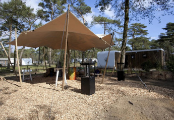 Buitenplek met zeildoek en moderne lodges bij Modus L, De Zanding, Nederland.