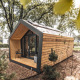 Moderne træhytte kaldet Solo Retreat midt i en skov fyldt med grønne træer og naturlig ro.