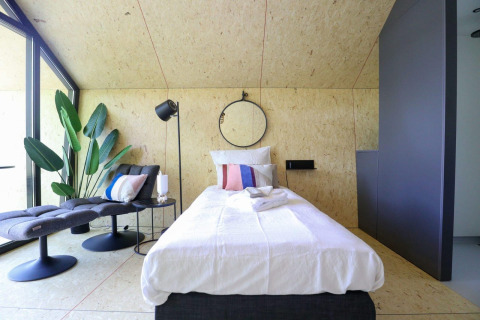 Modernes Einzelzimmer im Solo Retreat bei De Zanding, Niederlande, mit stilvollem Interieur und Pflanzen.
