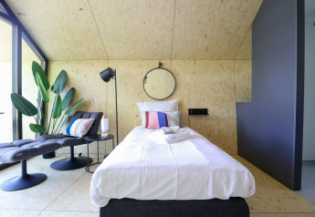 Modernes Einzelzimmer im Solo Retreat bei De Zanding, Niederlande, mit stilvollem Interieur und Pflanzen.