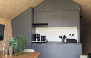 Moderne, kompakt køkken og spiseplads i træhytte fra Solo Retreat ved De Zanding, Holland.
