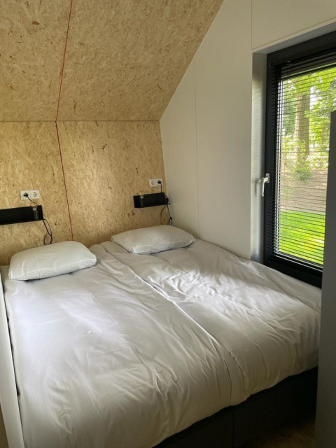 Moderne lodge met twee aparte bedden en groot raam bij Solo Retreat op De Zanding, Nederland.