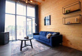 Soggiorno moderno nella Tiny House 2 al Marina Strandbad, Paesi Bassi, con divano blu e pareti in legno.