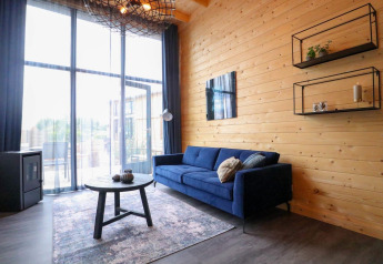Moderne stue i Tiny House 2 ved Marina Strandbad i Holland med blå sofa og store vinduer.