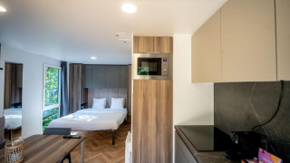 Moderna cabaña en Urban-Gardens Ieper, Bélgica con cama doble, cocina y mesa de comedor.