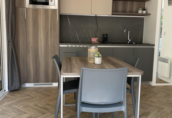 Moderne keuken en eetruimte met houten accenten in de Lodgep - IEPER bij Urban-Gardens Ieper, België.