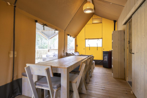 Interior de la tienda safari Ranger Lodge en Arden Parks - Signy l'Abbaye, Francia, con mesa comedor.