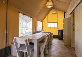 Interior de la tienda safari Ranger Lodge en Arden Parks - Signy l'Abbaye, Francia, con mesa comedor.