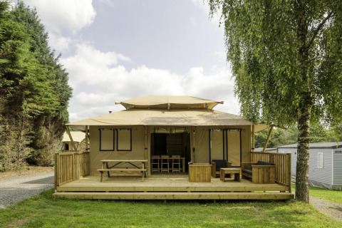 Stardust 40 Family Lodge safaritent bij Arden Parks - Signy l'Abbaye, Frankrijk, met houten terras en zitje.