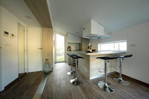Cocina y comedor compactos y modernos en Panorama Cottage, De Hooge Veluwe, Países Bajos con taburetes de bar.