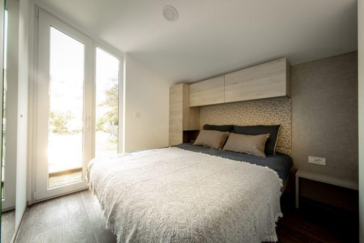 Modern bedroom with double bed and large windows at Panorama Cottage in De Hooge Veluwe, Netherlands.