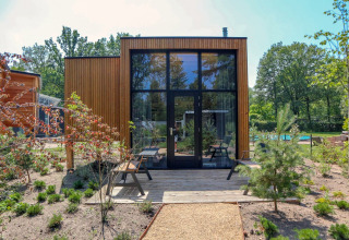 Tiny House moderne avec grandes fenêtres, façade bois et jardin au De Hooge Veluwe, Pays-Bas.
