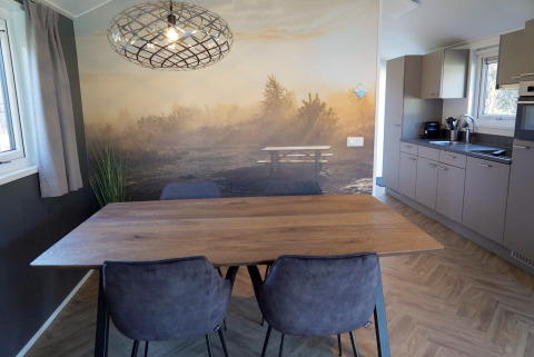 Coin repas au lodge Velthorst à De Hooge Veluwe, Pays-Bas, avec fresque murale et cuisine moderne.