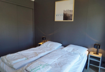 Modern Velthorst lodge bedroom at De Hooge Veluwe in the Netherlands with two single beds and minimalist decor.