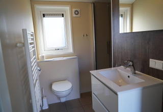 Modernes Badezimmer in der Velthorst Lodge bei De Hooge Veluwe in den Niederlanden mit WC und Waschbecken.