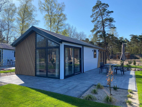 Moderne Lodge Velthorst im De Hooge Veluwe, Niederlande, mit Terrasse und Waldumgebung bei Tageslicht.