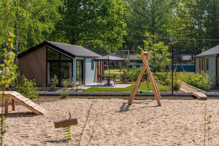 Modernos lodges en Velthorst De Hooge Veluwe, Países Bajos, con área de juegos y vegetación.