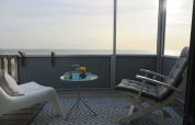 Vista del balcón en Beach house 'Dishoek 60', Zeeland, Países Bajos, con el mar al fondo y asientos cómodos.