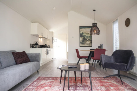 Moderne stue og køkken i Forest Lodge ved De Hooge Veluwe, Holland, med stilfuld indretning og naturligt lys.