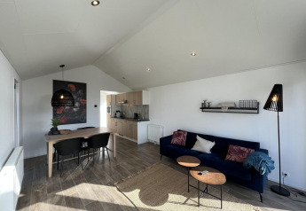 Moderne stue og køkken i Forest Lodge ved De Hooge Veluwe i Holland, med lyse farver og stilfulde møbler.