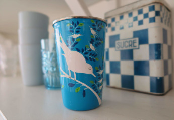 Gobelet bleu avec motif d’oiseaux devant une boîte 'Sucre', dans Beach house Dishoek 60, Zeeland, Pays-Bas.