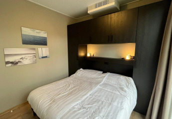 Bedroom at the Cube lodge at EuroParcs Ruinen, Netherlands, with a double bed and modern decor.
