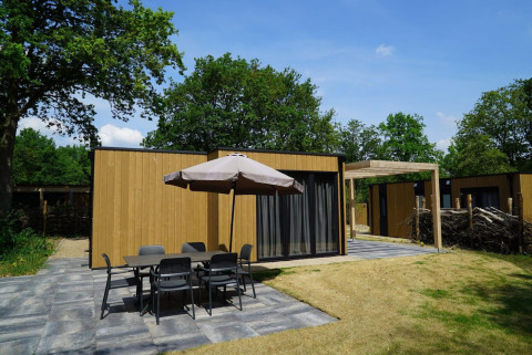 Buitenruimte bij Cube-lodge in EuroParcs Ruinen, Nederland, met terras, tafel en stoelen.