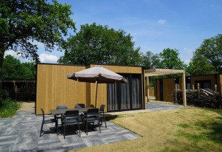 Buitenruimte bij Cube-lodge in EuroParcs Ruinen, Nederland, met terras, tafel en stoelen.