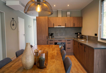 Moderne keuken en eetruimte in Cube lodge bij EuroParcs Ruinen, Nederland, met houten afwerking.