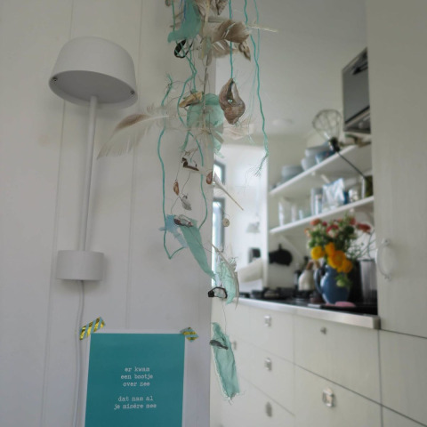 Intérieur de la maison de plage Dishoek 60, décorée de fleurs, plumes et éléments marins à Zeeland.