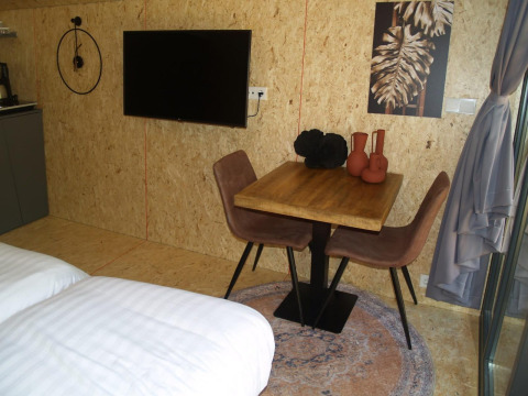 Solo Retreat tiny house a EuroParcs Ruinen: tavolo da pranzo, TV e arredamento moderno e accogliente.