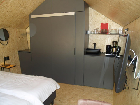 Tiny house moderna Solo Retreat a EuroParcs Ruinen nei Paesi Bassi con letto, cucina e TV.