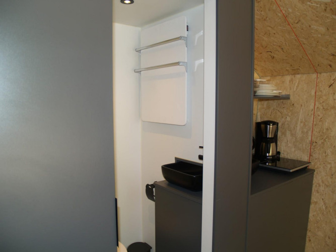 Kleine Küche im Solo Retreat im EuroParcs Ruinen, Niederlande, mit Kaffeemaschine und Spüle.