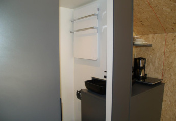 Cocina pequeña y moderna en la casa Solo Retreat de EuroParcs Ruinen, Países Bajos, con accesorios básicos.