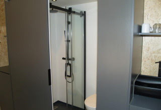 Bagno moderno con doccia e WC in una tiny house presso Solo Retreat, EuroParcs Ruinen, Paesi Bassi.