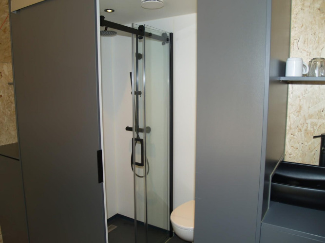 Modernes Badezimmer mit Dusche und WC im Tiny House Solo Retreat im EuroParcs Ruinen, Niederlande.