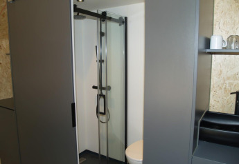Salle de bain moderne avec douche et toilettes dans une tiny house Solo Retreat, EuroParcs Ruinen, Pays-Bas.
