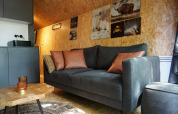 Zithoek in de tiny house Solo Retreat bij EuroParcs Ruinen, Nederland, met comfortabele sofa en kunst.