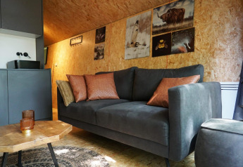 Woonruimte in de tiny house Solo Retreat bij EuroParcs Ruinen, Nederland, met bank en wanddecoratie.