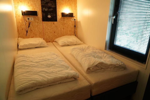Et lille, hyggeligt værelse med to enkeltsenge i Solo Retreat på EuroParcs Ruinen, Holland.
