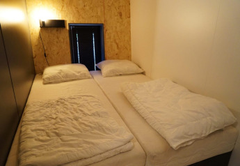 Twee eenpersoonsbedden in een klein, minimalistisch ingericht Solo Retreat huisje bij EuroParcs Ruinen.