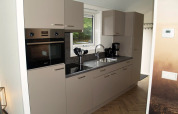 Modern kitchen in Velthorst lodge at EuroParcs Ruinen Netherlands, with beige cabinets and appliances.
