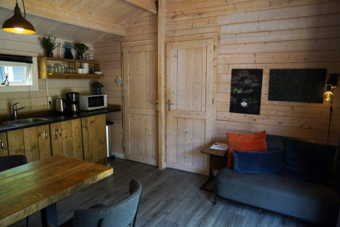 Soggiorno e cucina accoglienti nel lodge Drentse kap a EuroParcs Ruinen, Paesi Bassi, con arredo in legno.