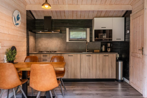 Cucina moderna e zona pranzo in un lodge in legno a Drentse kap, EuroParcs Ruinen, Paesi Bassi.