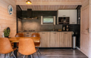 Moderne keuken en eetruimte in houten lodge bij Drentse kap, EuroParcs Ruinen, Nederland.