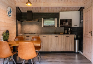 Cucina moderna e zona pranzo in un lodge in legno a Drentse kap, EuroParcs Ruinen, Paesi Bassi.