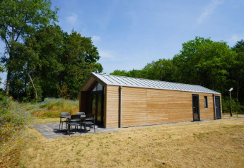 Modernes Holzhaus, Forest Lodge bei EuroParcs Ruinen in den Niederlanden, mit Terrasse im Grünen.